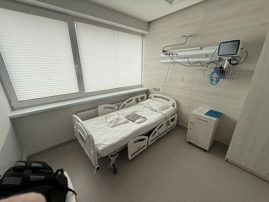 Empty hospital room at Nordclinic with the bed made and a gown folded on it