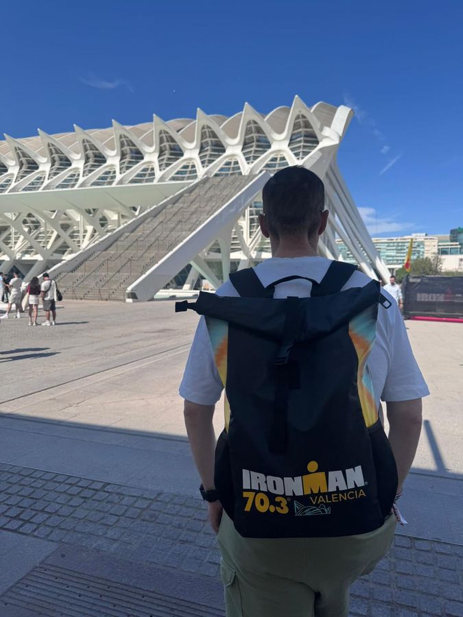 Jamie facing the City of Arts and Sciences with an IRONMAN 70.3 Valencia backpack