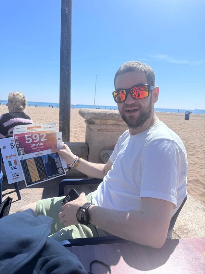Jamie holding race number 592 on the beach at Valencia